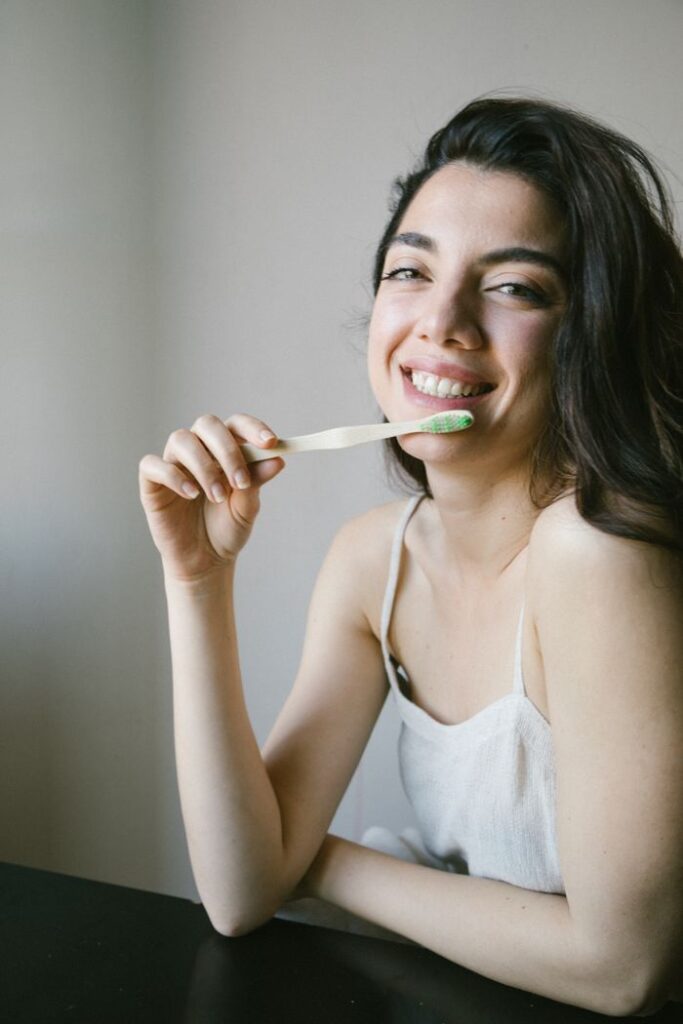 A joyful woman promotes dental hygiene with an eco-friendly toothbrush indoors.